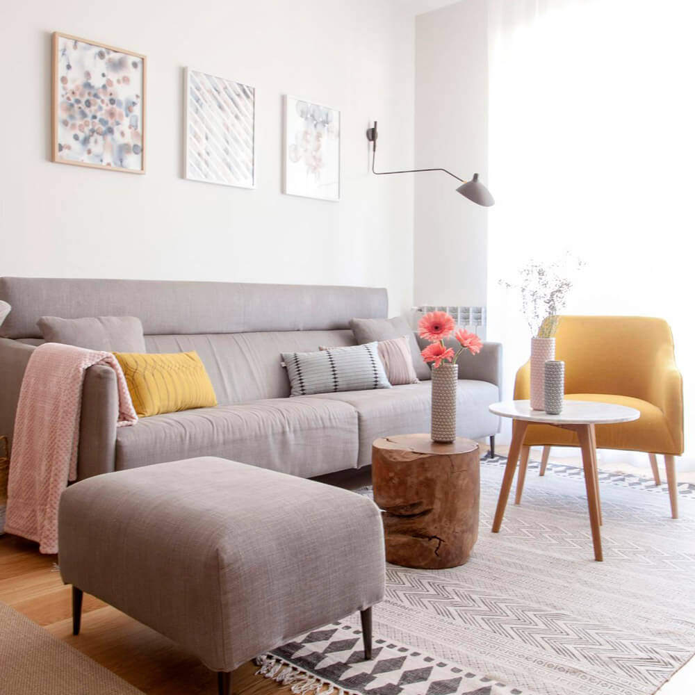 Proyecto de R de Room Amazing Homes. Vista de estar-comedor de estilo nórdico compuesto por mesa extensible de madera de roble, sillas Zuiver, sofá y ottoman a juego y butaca en color mostaza.