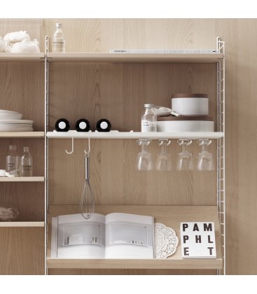 Estantería STRING de 3 módulos con 1 cabinet y 1 mesa plegable en fresno con paneles blancos.