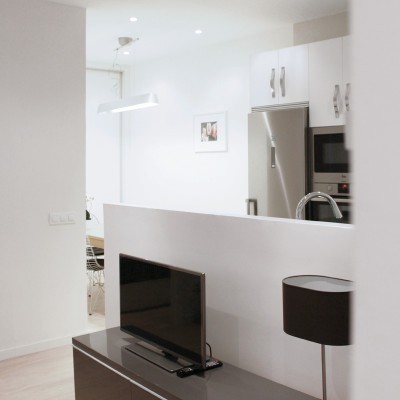 La envolvente neutra y los muebles de cocina blancos ayudan a integrar muy bien la cocina en el estar.