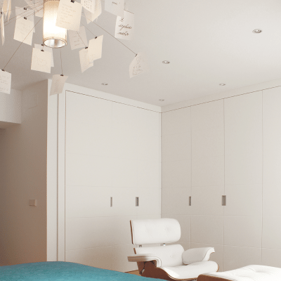 En la zona de vestidor, completa la decoración el Lounge Chair con Ottoman de los Eames en blanco.