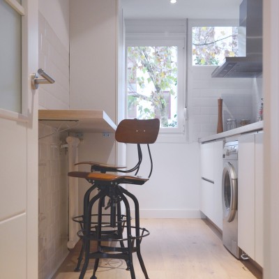Para la cocina se propuso una distribución del amueblamiento más funcional y se rescató parte de una ventana tapada anteriormente por muebles. Se incorporó así mismo una pequeña barra de madera para los desayunos.