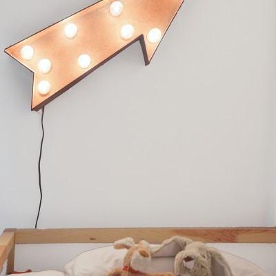 La luz en forma de flecha sobre la cama da un toque divertido y ayuda a dar estilo y luminosidad.