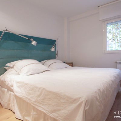 En el dormitorio principal, la propietaria quería instalar un cuadro con tonos azules al que tenía un cariño especial. Por eso propusimos un cabecero en los mismos tonos que otorgase un estética homogénea a la estancia.