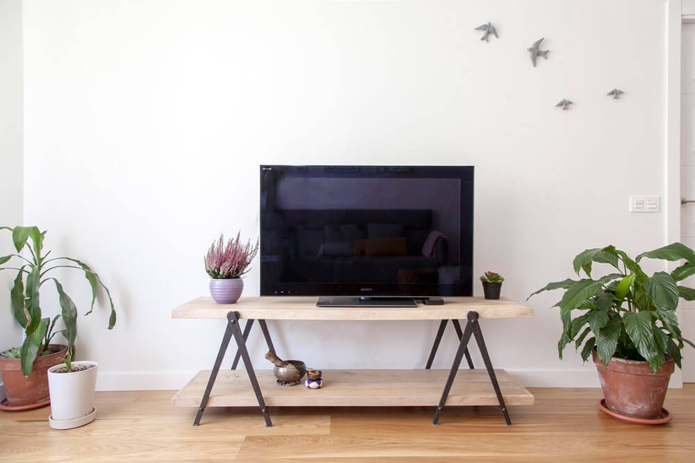 Proyecto de R de Room Amazing Homes. Mueble de TV modelo PLATFORM compuesto por dos baldas de madera maciza. Decoración de pared con golondrinas esmaltadas en color gris claro.