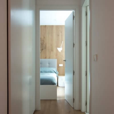 RdeRoom-MADERA reforma e interiorismo de vivienda para alquiler de lujo en Malasaña. vista del dormitorio desde el pasillo.