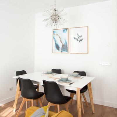 Proyecto de reforma de vivienda en Chamberí II (Madrid) de R de Room. Estar-comedor de estilo escandinavo. Lámpara de techo Sputnik resturada. Láminas de gran formado de Desenio.