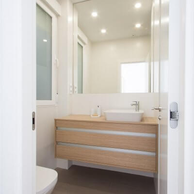 Proyecto de reforma de vivienda en Chamberí II (Madrid) de R de Room. Baño minimalista en balnco y madera. Espejo a medida.