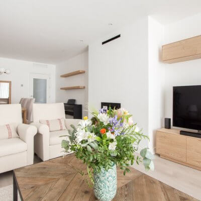 En la estancia, de casi 30 m2, diferenciamos claramente la zona de estar de la de comedor. Jugamos con los tonos neutros y las maderas para crear un ambiente cálido y muy acogedor. Todo el mobiliario es de R de Room.