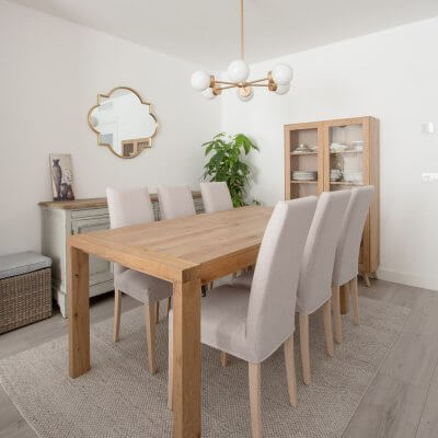 En el comedor ganamos almacenaje con un aparador vintage y una vitrina de aspecto muy contemporáneo. La vitrina, el mueble de TV y los estantes sobre el piano son de la serie NORWAY de R de Room Shop. Las sillas tapizadas son desenfundables. Todo el mobiliario es de R de Room.