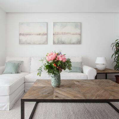En la zona de estar, las plantas y dos mesas gemelas de madera y hierro lacado en negro dan el toque cálido. El sofá blanco es desenfundable. Todo el mobiliario es de R de Room.