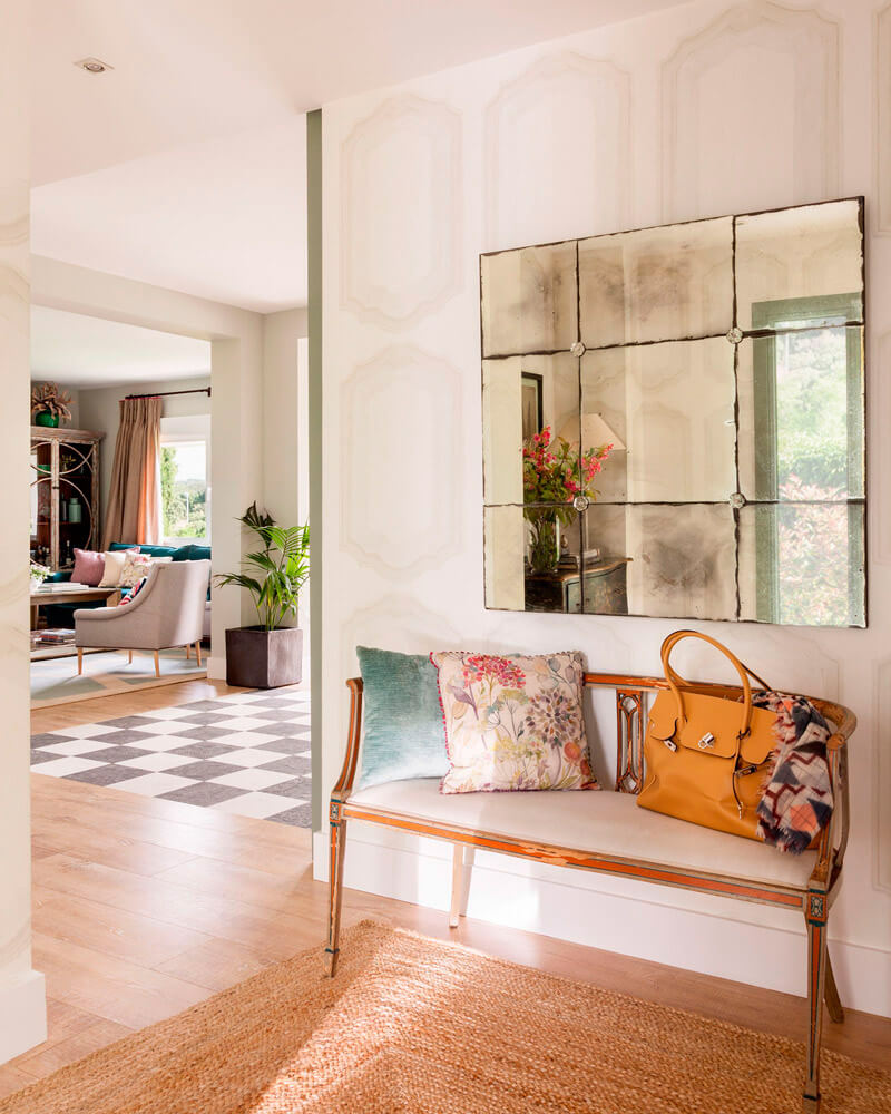 Un salón con una cómoda de madera y un cuadro de una casa en la pared.