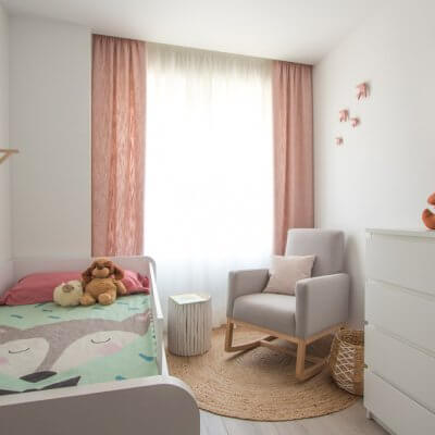 A pesar de las dimensiones reducidas de este dormitorio infantil, conseguimos incorporar una cama nido, una mecedero tapizada de lectura y lactancia y una zona de juego. También ganamos espacio de almacenaje.