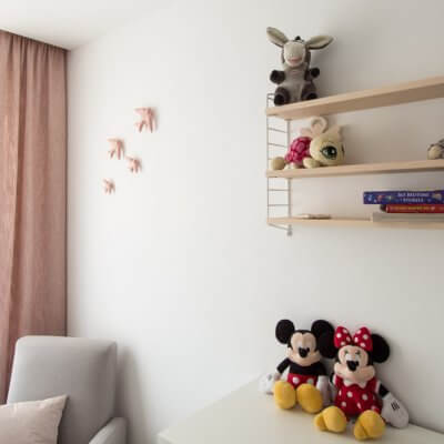 Una estantería String Pcket y un conjunto de 4 golondrinas de cerámica esmaltada en color rosa decoran la pared de este dormitorio infantil.