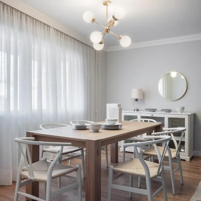 Comedor de vivienda en Madrid. Mesa rectangular de madera de roble extensible. Sillas CH24 blancas. Lámpara suspendida dorada. Comedor contemporáneo, luminoso y acogedor. Proyecto de reforma e interiorismo de R de Room.