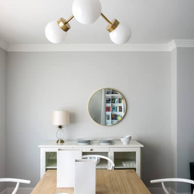 Comedor de vivienda en Madrid. Mesa rectangular de madera de roble extensible. Sillas CH24 blancas. Lámpara suspendida dorada. Comedor contemporáneo, luminoso y acogedor.