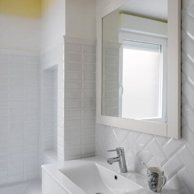 Baño para niños. Zócalo de azulejo esmaltado biselado tipo metro en color blanco. Pared pintada en color amarillo. Degradado de pintura en pared. Mueble de lavabo estilo retro. Baño luminoso. Proyecto de reforma e interiorismo de R de Room.
