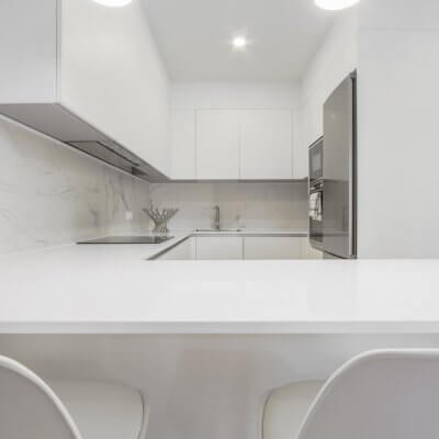 Proyecto de reforma en Chamberí (Madrid) de R de Room. Cocina abierta con barra. Frente de mármol blanco Calacatta