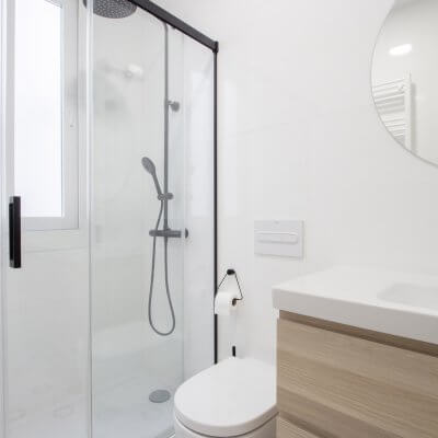 Proyecto de reforma en Chamberí (Madrid) de R de Room. Baño en blanco y negro. Suelo teselas Hisbalit. Grifería, mampara y focos negros.