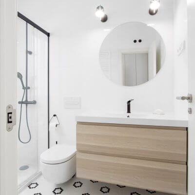 Proyecto de reforma en Chamberí (Madrid) de R de Room. Baño en blanco y negro. Suelo teselas Hisbalit. Grifería, mampara y focos negros.