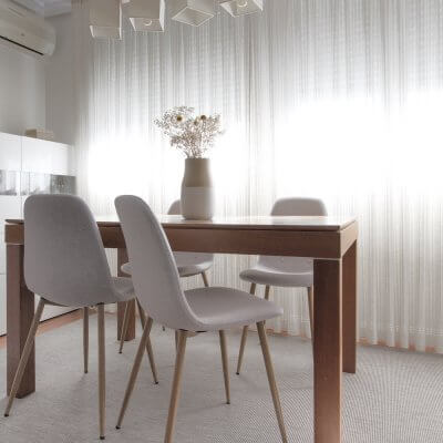 Interiorismo de vivienda_estar comedor-sofá gris-ambiente cálido-mesa de comedor-sillas tapizadas-sillas grises.