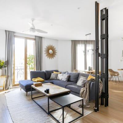 Salón-comedor con interiorismo de inspiración industrial y detalles retro. Tiene incorporada una zona de trabao resuelta con una estantería modular String. Proyecto de R de Room.