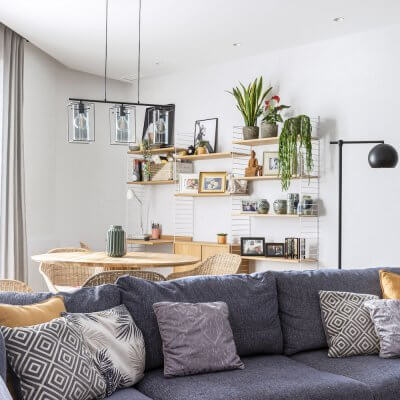 Salón-comedor con interiorismo de inspiración industrial y detalles retro. Tiene incorporada una zona de trabao resuelta con una estantería modular String. Proyecto de R de Room.
