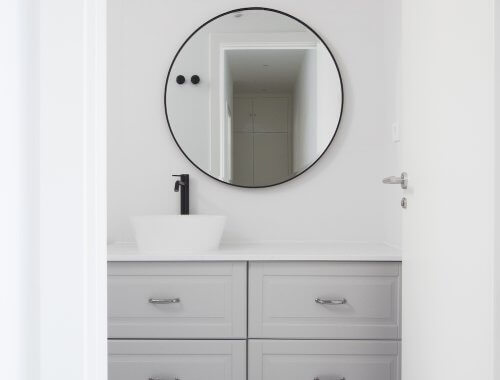 Baño de cortesía moderno en gris, blanco y negro. Proyecto de R de Room.