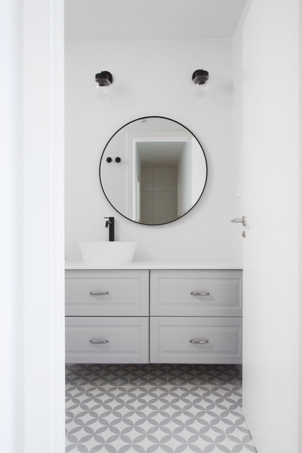 Baño de cortesía moderno en gris, blanco y negro. Proyecto de R de Room.