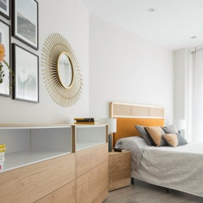 Dormitorio con muebles de madera y cabecero de rejilla y terciopelo caldera. Proyecto de R de Room.