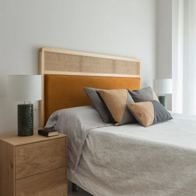 Dormitorio con muebles de madera y cabecero de rejilla y terciopelo caldera. Proyecto de R de Room.
