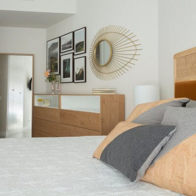 Dormitorio con muebles de madera y cabecero de rejilla y terciopelo caldera. Proyecto de R de Room.