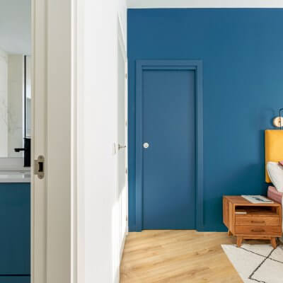 Dormitorio principal. Pared de cabecero azul. Vista con baño en suite. Proyecto de R de Room.