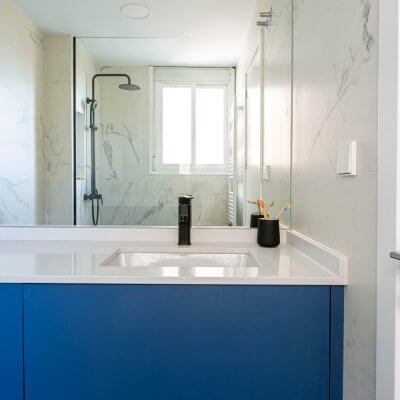 Baño en suite. Mármol blanco y mueble a medida azul. Proyecto de R de Room.