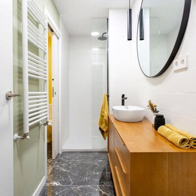 Baño blanco, verde, amarillo y negro. Mueble de lavabo aparador mid-century. Proyecto de R de Room.