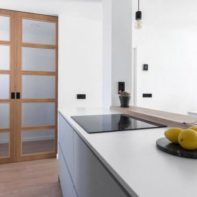 Cocina abierta con zona de lavadero. Puertas de madera. Proyecto R de Room.