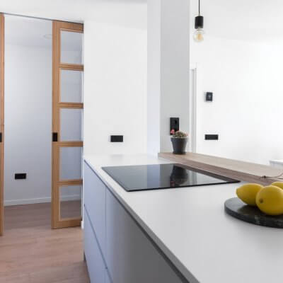 Cocina abierta con zona de lavadero. Puertas de madera. Proyecto R de Room.