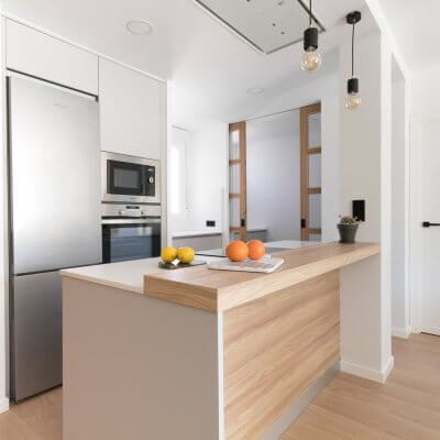 Cocina abierta gris claro y madera. Puertas con cuarterones. Proyecto R de Room.