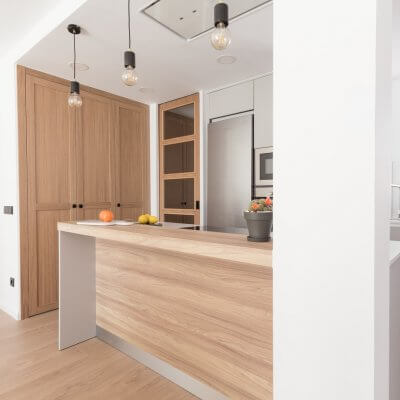 Cocina abierta gris claro y madera. Puertas con cuarterones. Proyecto R de Room.