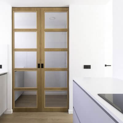 Cocina abierta con zona de lavadero. Puertas de madera. Proyecto R de Room.