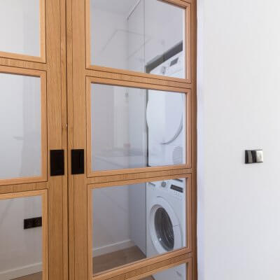 Cocina abierta con zona de lavadero. Puerta de madera con cuarterones. Proyecto R de Room.