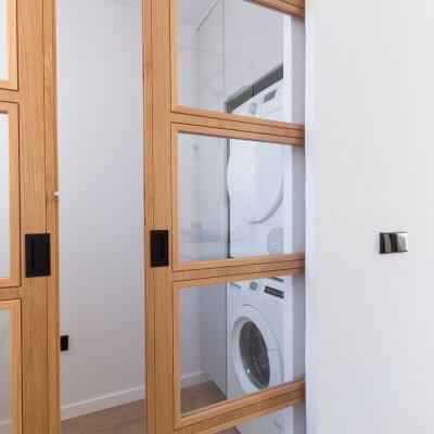 Cocina abierta con zona de lavadero. Puerta de madera con cuarterones. Proyecto R de Room.
