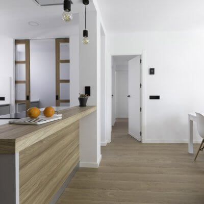 Cocina abierta gris claro y madera. Puertas con cuarterones. Proyecto R de Room.