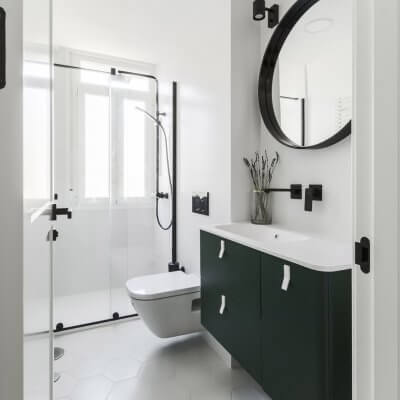 Baño principal con mueble verde y toques negros. Proyecto R de Room.