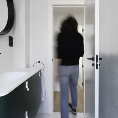 Baño principal con mueble y mural verdes y toques negros. Proyecto R de Room.