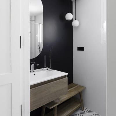 Baño de cortesía. Pintura negra y azulejo geométrico en b&n. Proyecto R de Room.