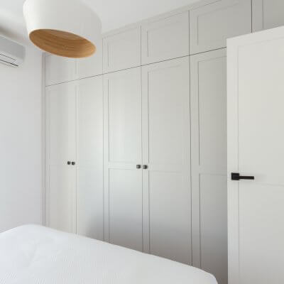 Carpintería interior con cuarterones en gris y blanco. Manillas y pomos negros. Proyecto R de Room.